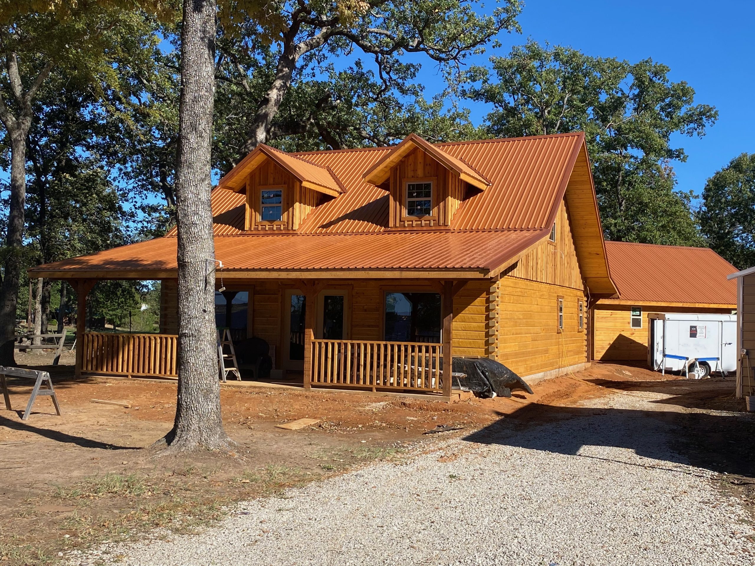 Log cabin with new copper standing seam metal roof installation in East Texas