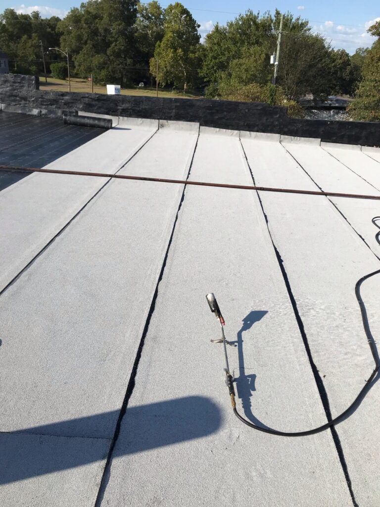 Flat roof leak repair - membrane patch and flashing work on a commercial building in East Texas