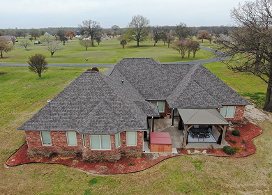 Aerial view of new charcoal shingle roof on brick ranch home near Longview, TX